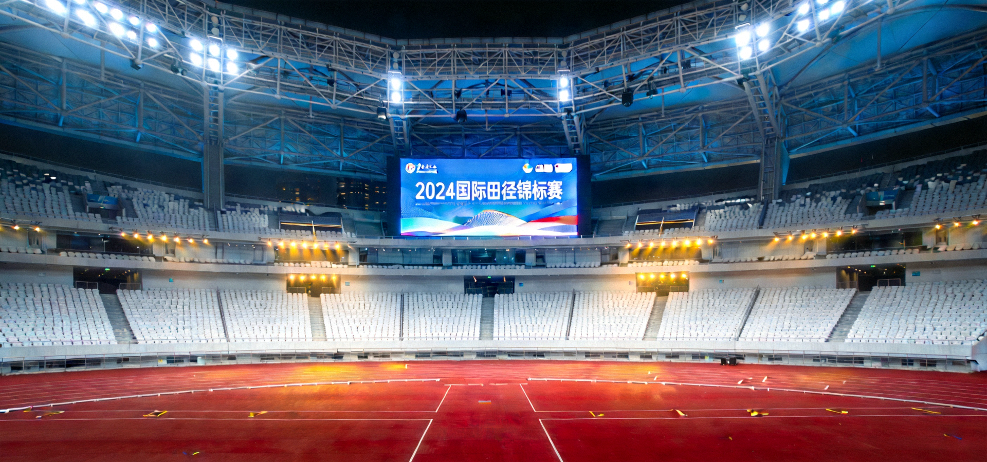 现代化体育竞技场馆全景，灯光照亮跑道与看台，营造专业赛事氛围